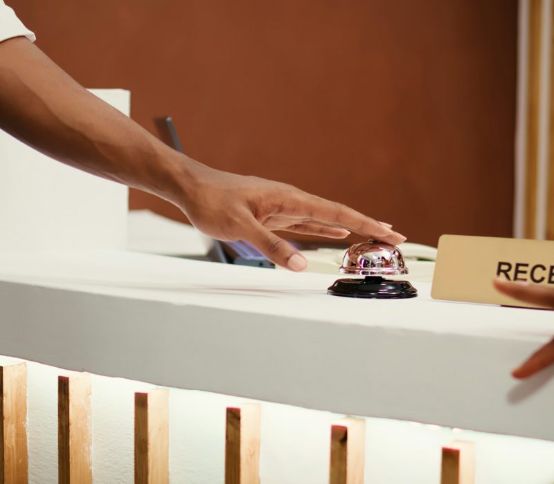 Tourists ringing concierge bell close up